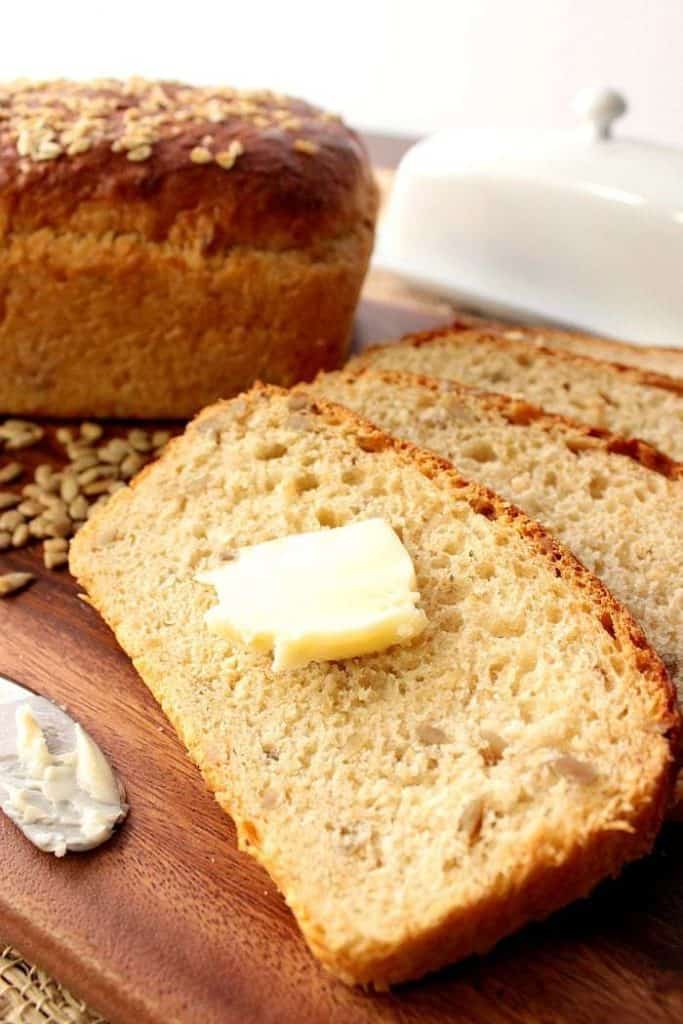 Closeup photo of slices of oatmeal honey bread with butter. Popular Thanksgiving side dish recipe roundup.