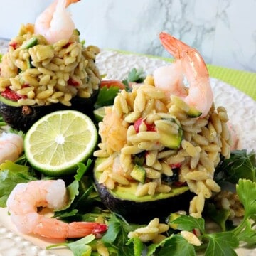 Cooked shrimp on top of an Chilled Orzo Pasta Stuffed Avocado.