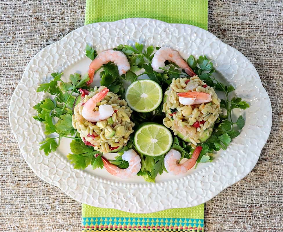 An over head photo of a platter of chilled pasta and shrimp salad stuffed into avocado halves.