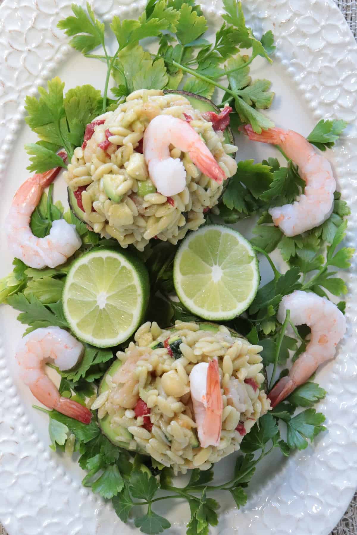 An overhead photo of two Chilled Seafood Pasta Stuffed Avocados on a pretty plate.