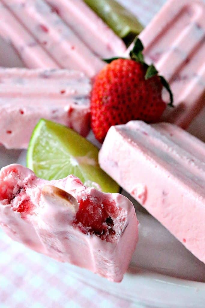 Closeup vertical photo of a frozen strawberry lime whipped keto pop with a bite taken out.