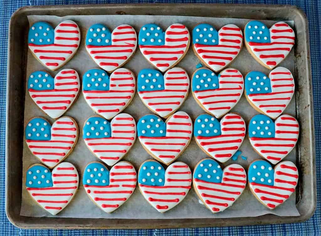 A baking sheet filled with American Flag Heart shaped sugar cookies.