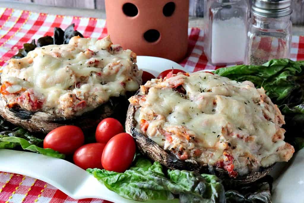 Two giant mushroom caps on a plate stuffed with chicken Parmesan and melted cheese.