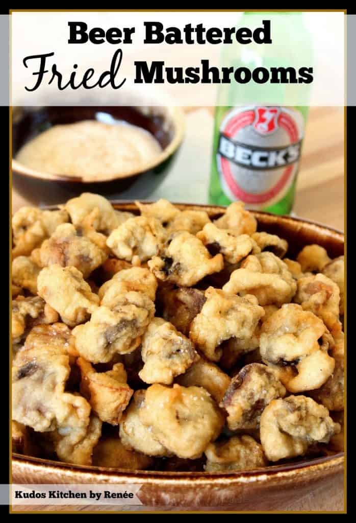 Bowl of fried mushrooms with a bottle of beer in the background.