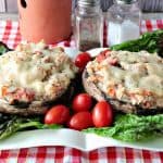 Speedy Chicken Parmesan Portobello Stuffed Mushroom on a plate with lettuce and tomatoes