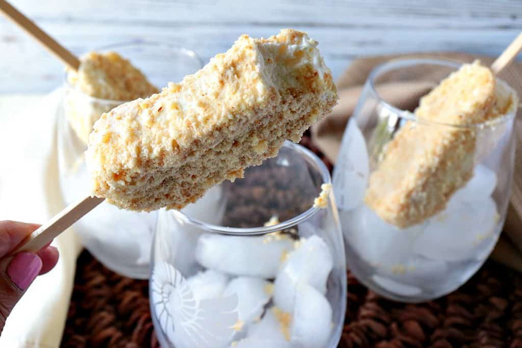 A closeup image of three toasted almond ice cream bars in glass drinking glasses with ice cubes.