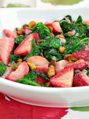 A white bowl filled with Creamed Spinach and Strawberries salad.
