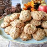 A platter of apple oatmeal cookies with fresh apples in the background and sunflowers