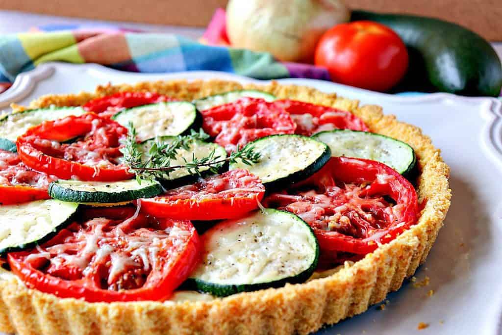 I'm not sure which part of this Fresh Tomato Tart I love the best! Is it the slices of garden fresh tomatoes and zucchini, the crunchy cornflake crust, or the layer of thyme-infused caramelized onions? - kudoskitchenbyrenee.com Late summer vegetables beckon to be nestled into this Fresh Tomato Tart with Zucchini & Caramelized Onions. - kudoskitchenbyrenee.com