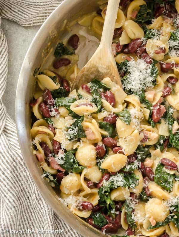 Easy Weeknight Dinner Recipes. Shell pasta with beans and spinach in a skillet.