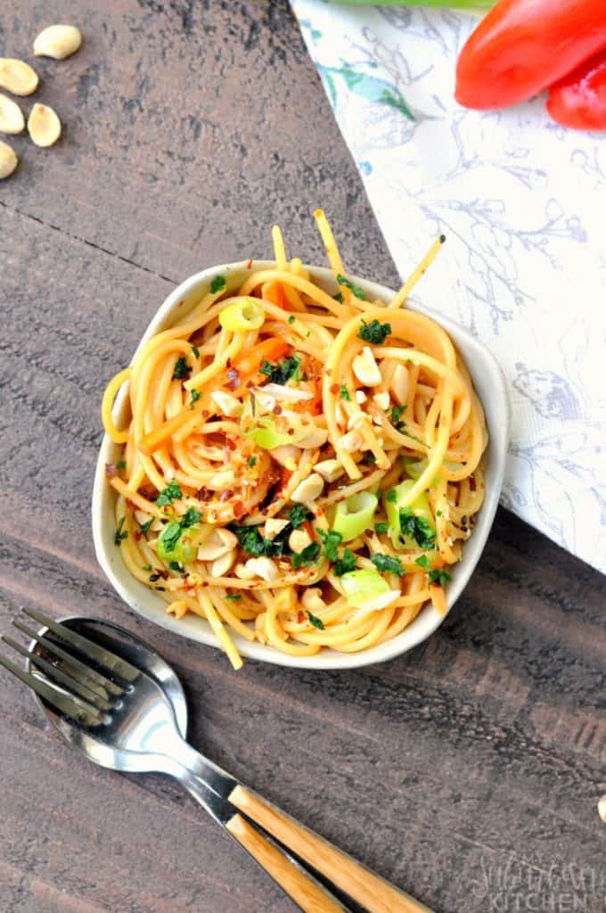 Easy Weeknight Dinner Recipes. Overhead picture of noodles in a white bowl with peanuts and tomatoes.