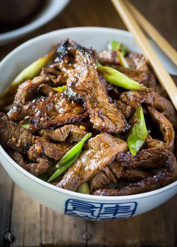 Easy Weeknight Dinner Recipes. Beef strips in a blue and white bowl with scallions.