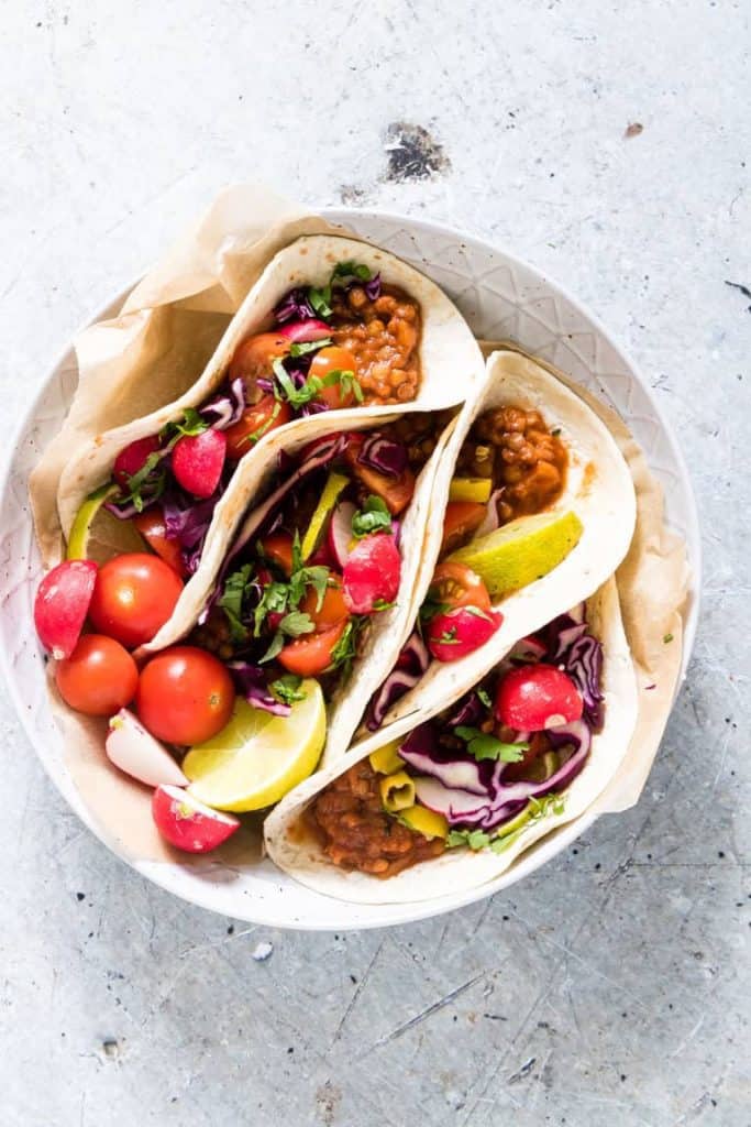 Easy Weeknight Dinner Recipes. Soft shell tacos in a bowl with tomatoes, limes and meat.