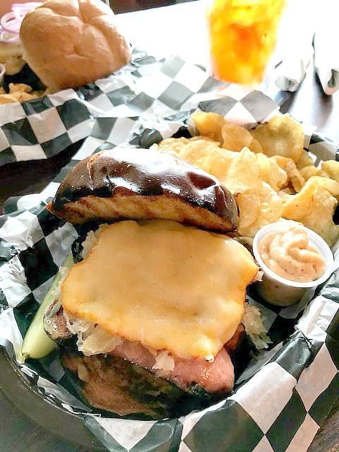 Overhead photo of a Knockwurst sandwich on a pretzel roll.