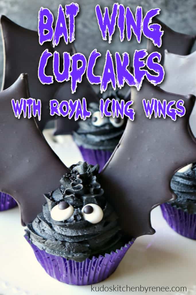 A vertical closeup image of a bat wing cupcake with royal icing wings and a title text overlay graphic in purple and white