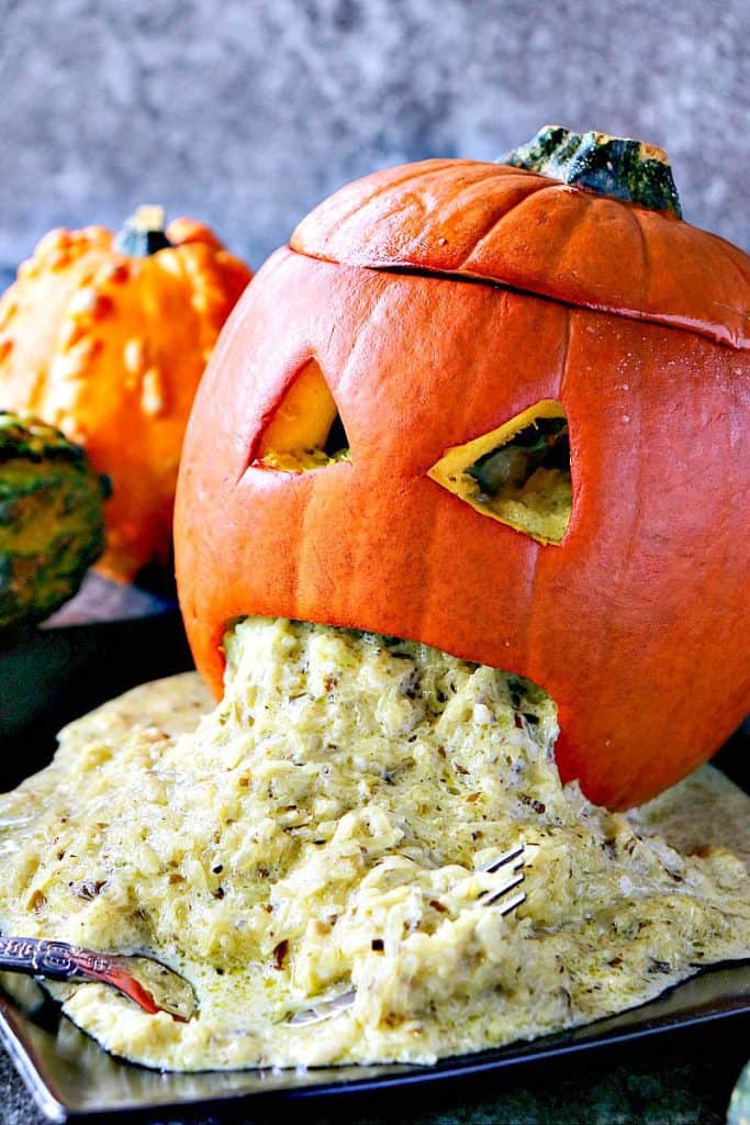 Vertical closeup photo of a carved pumpkin with spaghetti squash vomit for Halloween.