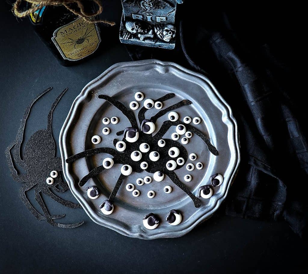 Overhead photo of a spooky gray plate filled with Homemade Candy Eyeballs and spiders.