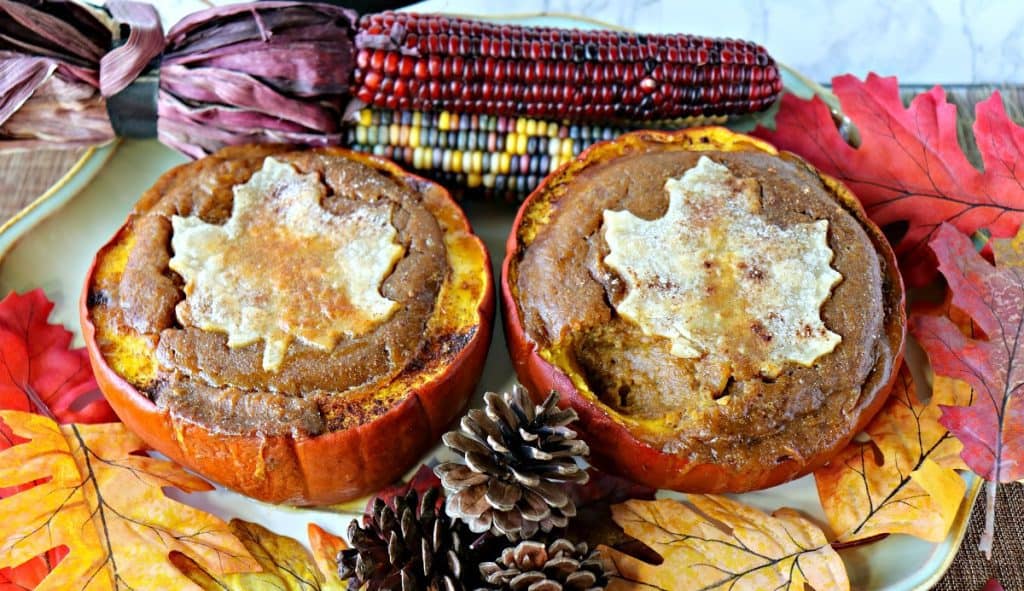 Horizontal overhead photo of two rustic pilgrim pumpkin pies for Thanksgiving dessert recipe roundup.