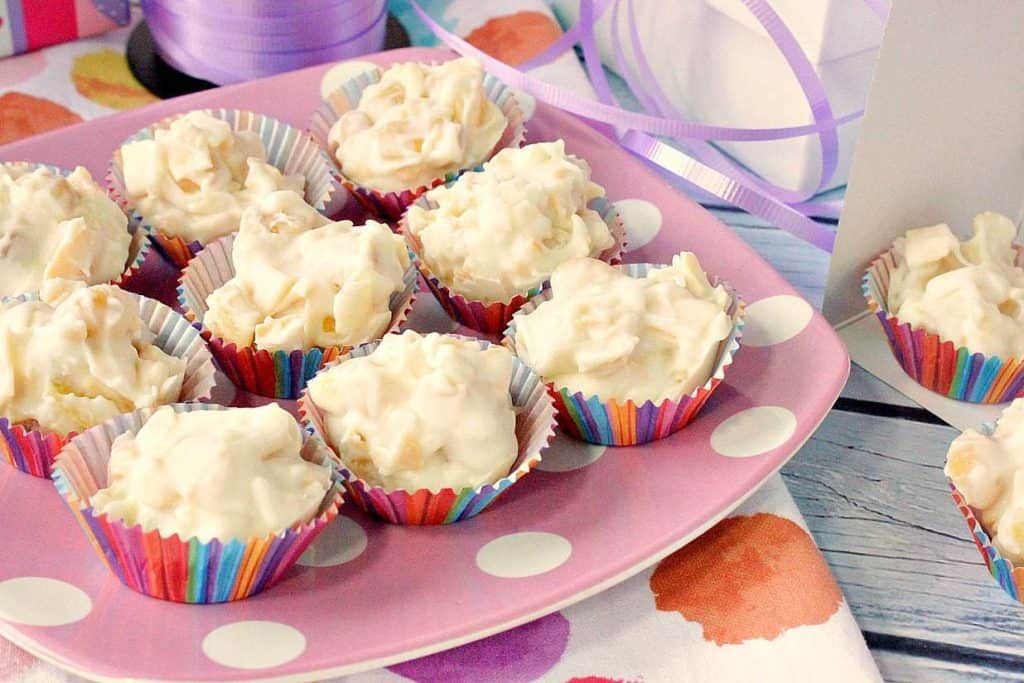 A colorful photo of a pink polka dot plate filled with tropical white chocolate candy bites.