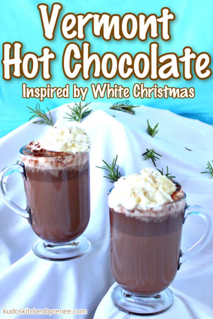 A vertical photo of two mugs of Vermont Hot Chocolate on a snow covered mountain with a title text overlay graphic.