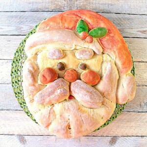 A cute Buttermilk Santa Shaped Bread with holly berry and a cap.