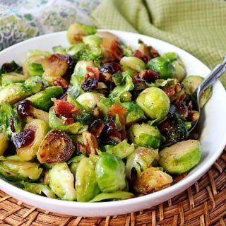 Sauteed Brussels Sprouts in a white bowl with a spoon.