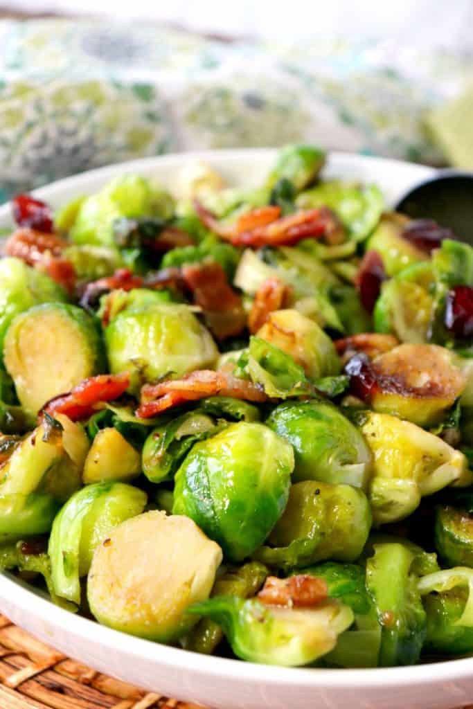 Closeup vertical image of sauteed Brussels sprouts with candied bacon.