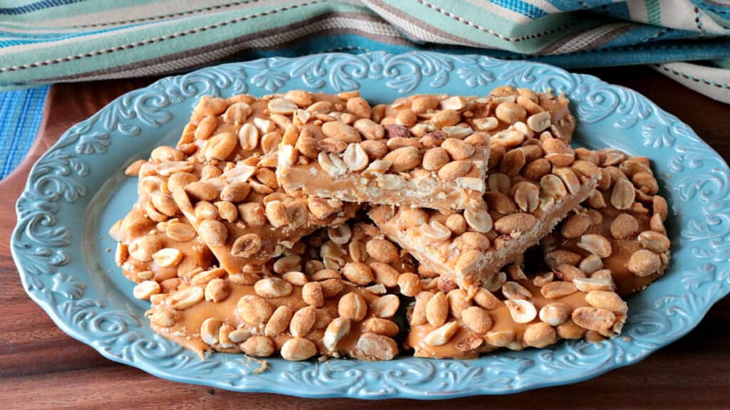 A stack of copycat payday candy bars on a pretty blue plate with scallops.