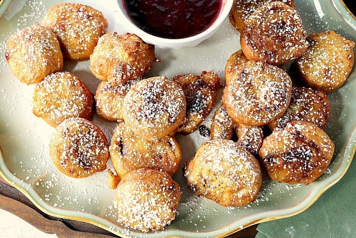 Overhead shot of a plate of Monte Cristo appetizers sprinkled with powdered sugar.