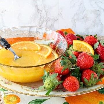 Homemade orange curd on a platter with strawberries.