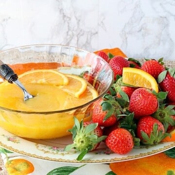 Homemade orange curd on a platter with strawberries.