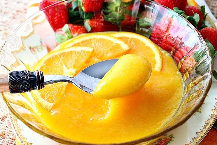 Closeup picture of a spoonful of homemade orange curd.