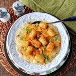 A white bowl filled with Tater Tot Chowder with a spoon.
