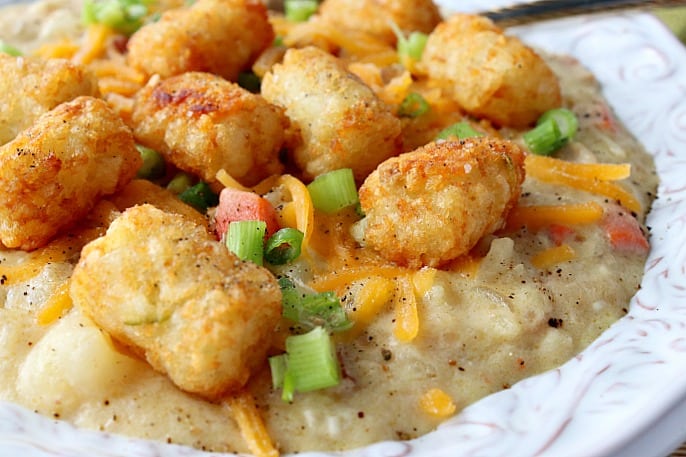 Closeup picture of tater tots on top of a bowl of tater tot chowder.