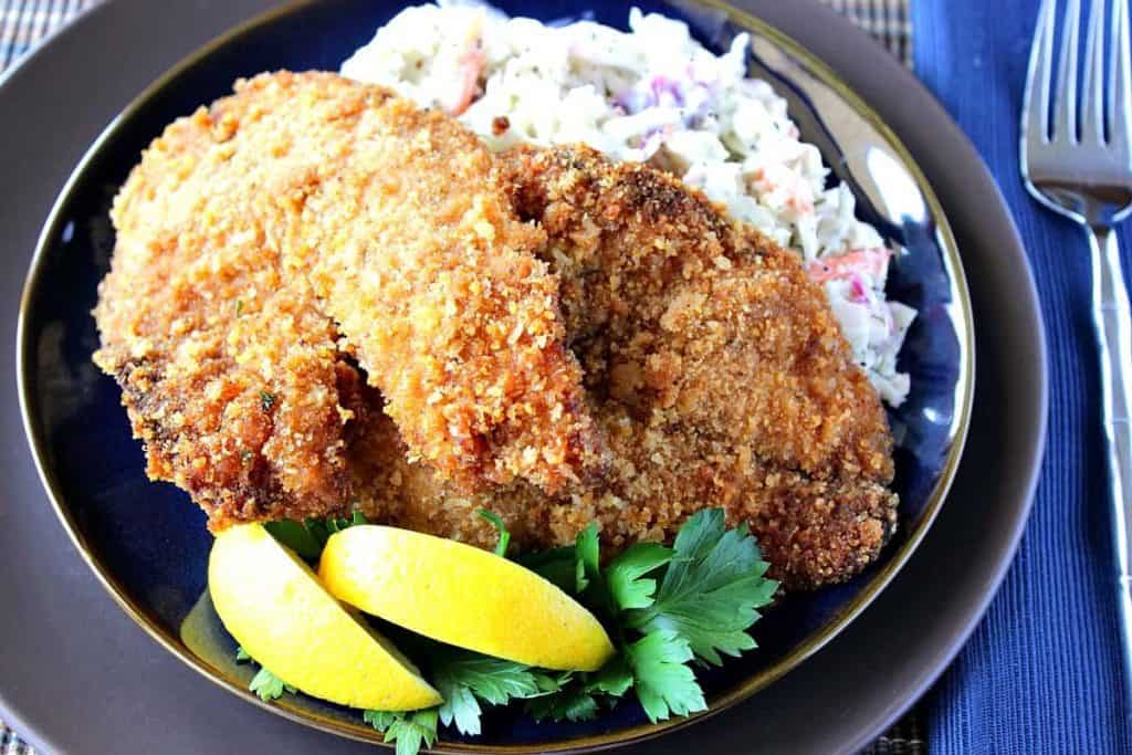 Fried Tilapia on a plate with parsley and lemon wedges - kudoskitcenbyrenee.com