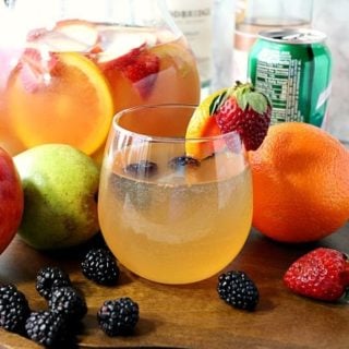 Blackberry Sangria Spritzer in a glass with a pitcher in the background.