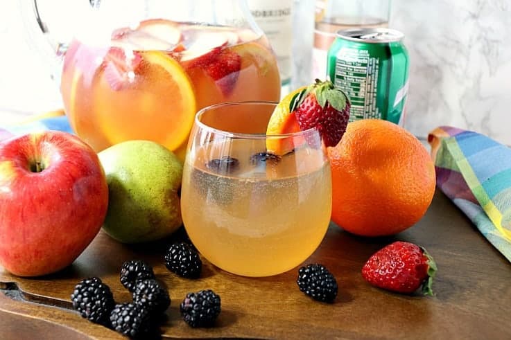 Blackberry Sangria Spritzer in a glass with a pitcher in the background.