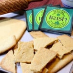 A bunch of broken pieces of Traditional Irish Shortbread along with some Irish napkins in the background.