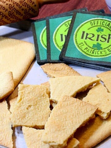 A bunch of broken pieces of Traditional Irish Shortbread along with some Irish napkins in the background.