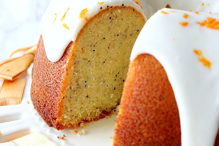 Close up picture of the inside of a moist orange bundt cake with banana and poppy seeds.
