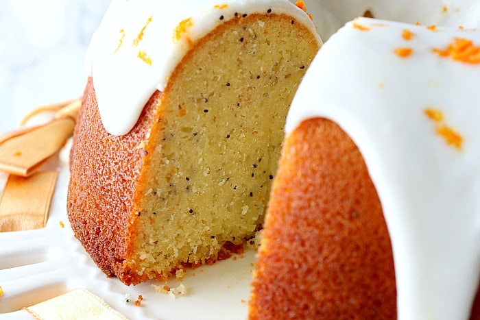 Close up picture of the inside of a moist orange bundt cake with banana and poppy seeds.