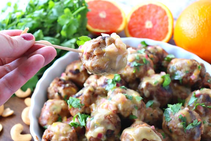 Closeup of a turkey meatball on a skewer with sauce