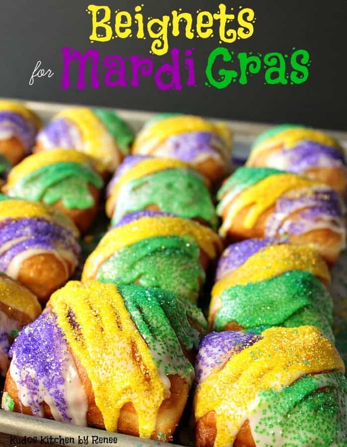 A vertical title text closeup image of purple, green and gold sanding sugar fried beignets. 