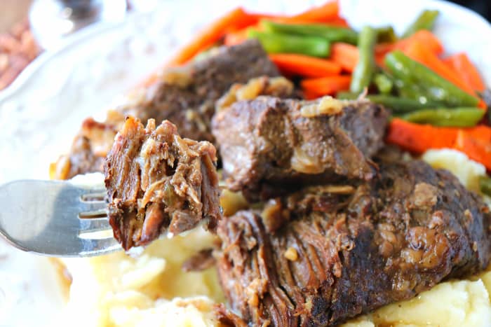 Closeup picture of short ribs on a fork.