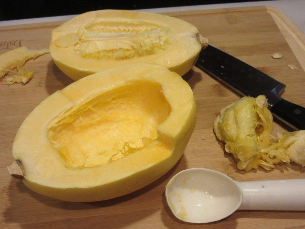 Split open spaghetti squash with the seeds taken out and an ice cream scoop