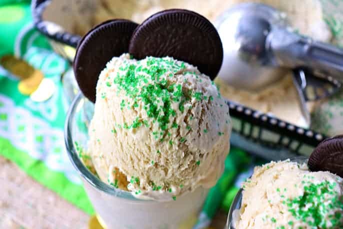 Two cookies in a glass of ice cream with green sprinkles.