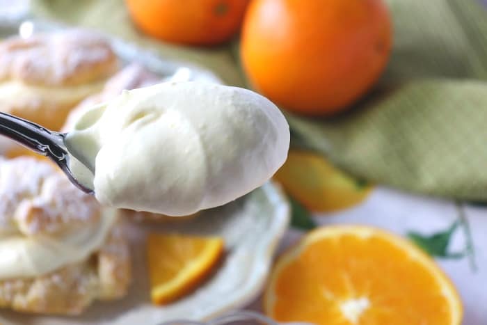 Closeup picture of orange curd whipped cream on a spoon