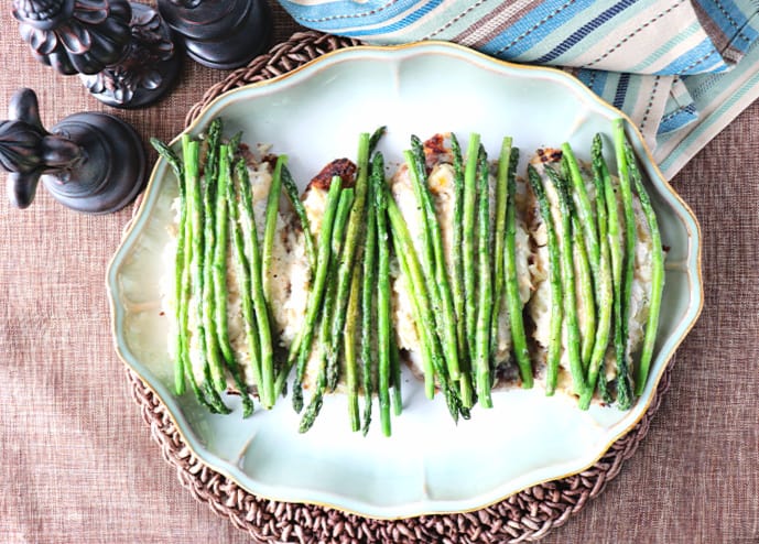 Overhead picture of a platter of chicken oscar with fresh asparagus spears