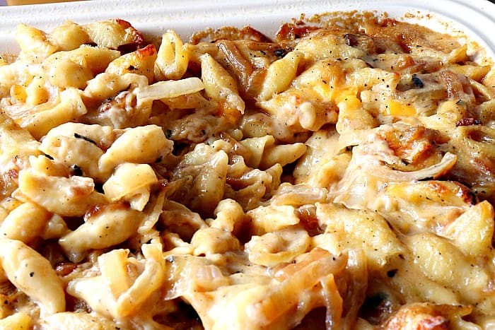 Closeup photo of cheesy shells and cheese with caramelized onions.