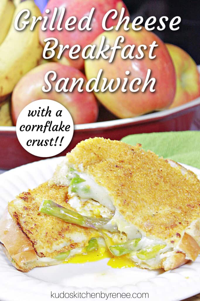 A vertical closeup of a sliced Grilled Cheese Breakfast Sandwich with a cornflake crust and a title text overlay graphic.